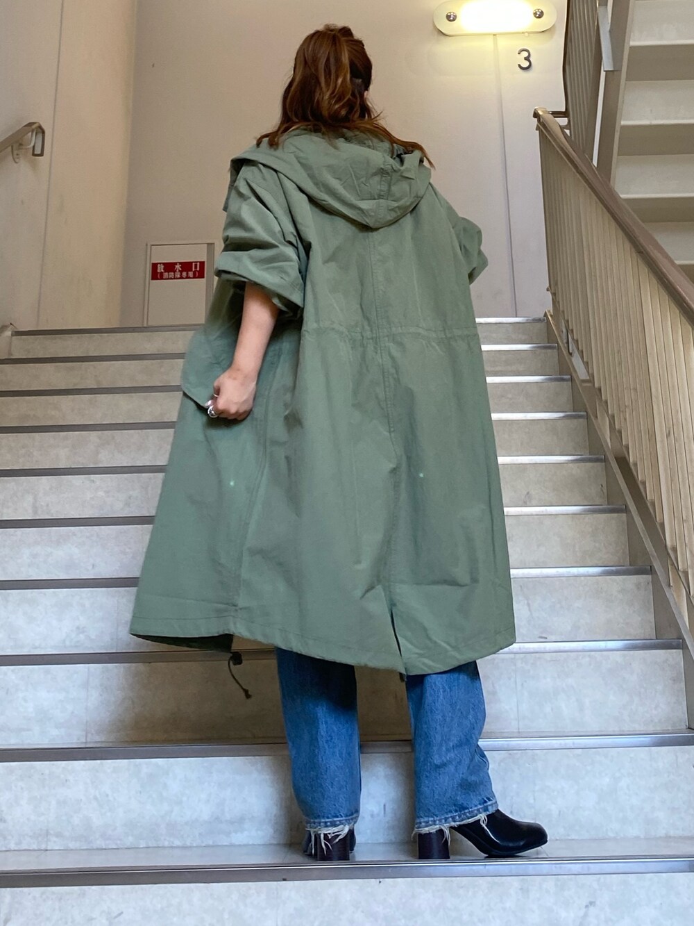 ピンク系のニット/セーター、グリーン系のブルゾン、ブルー系のデニムパンツを着用したレディースの秋コーディネートの3枚目の写真