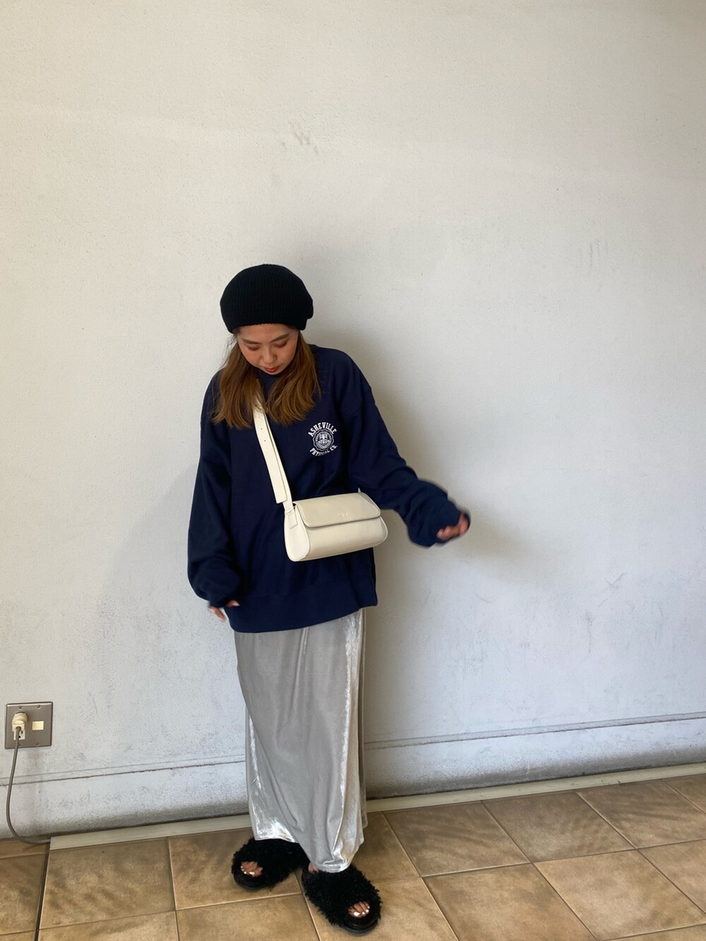 ブルー系のスウェット、グレー系のスカート、ホワイト系のショルダーバッグを着用したレディースの秋コーディネートの6枚目の写真