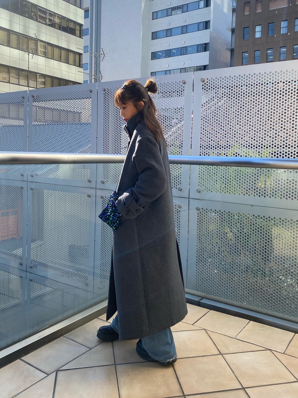 グレー系のその他アウター、ブルー系のデニムパンツ、グリーン系のショルダーバッグを着用したレディースの秋コーディネートの2枚目の写真