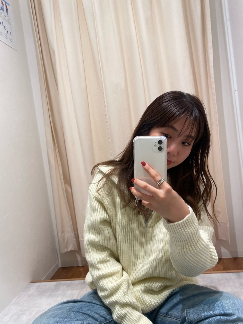 ホワイト系のニット/セーター、ブルー系のデニムパンツ、ホワイト系のTシャツ/カットソーを着用したレディースの冬コーディネートの6枚目の写真