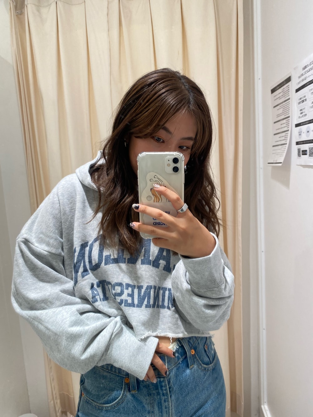 グレー系のパーカー、ブルー系のデニムパンツを着用したレディースの秋コーディネートの5枚目の写真