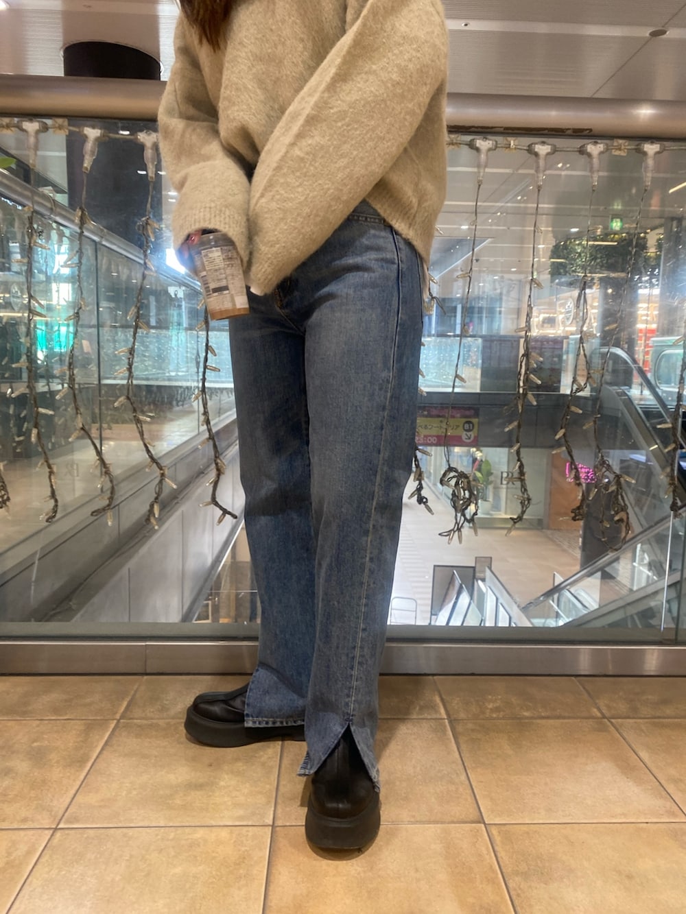 グレー系のニット/セーター、ブルー系のデニムパンツを着用したレディースの冬コーディネートの6枚目の写真