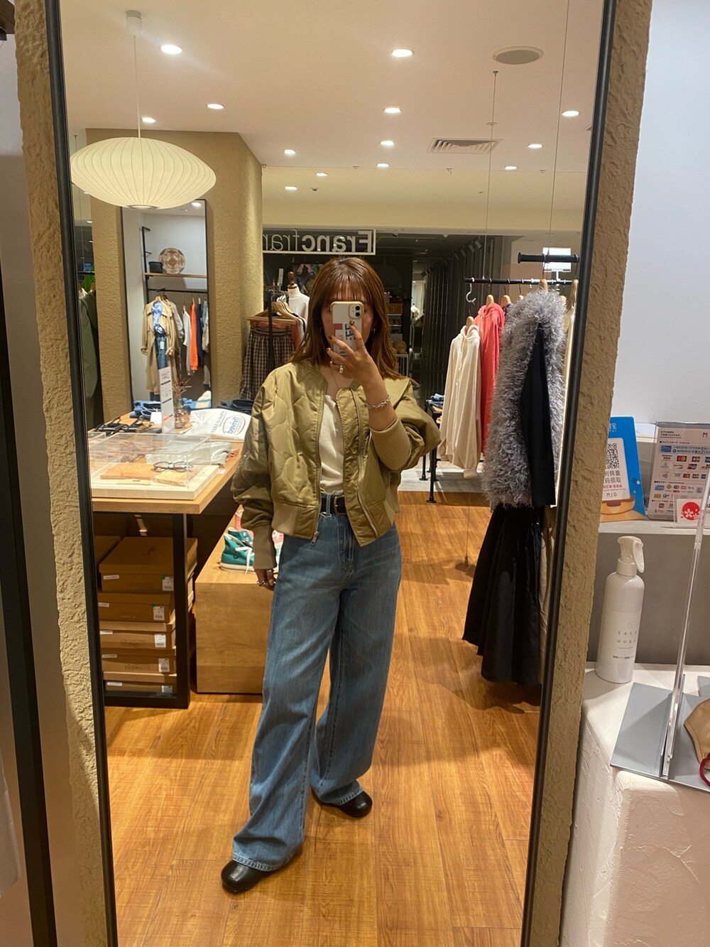 ベージュ系のブルゾン、ブルー系のデニムパンツ、ブラック系のブーツを着用したレディースの秋コーディネートの7枚目の写真