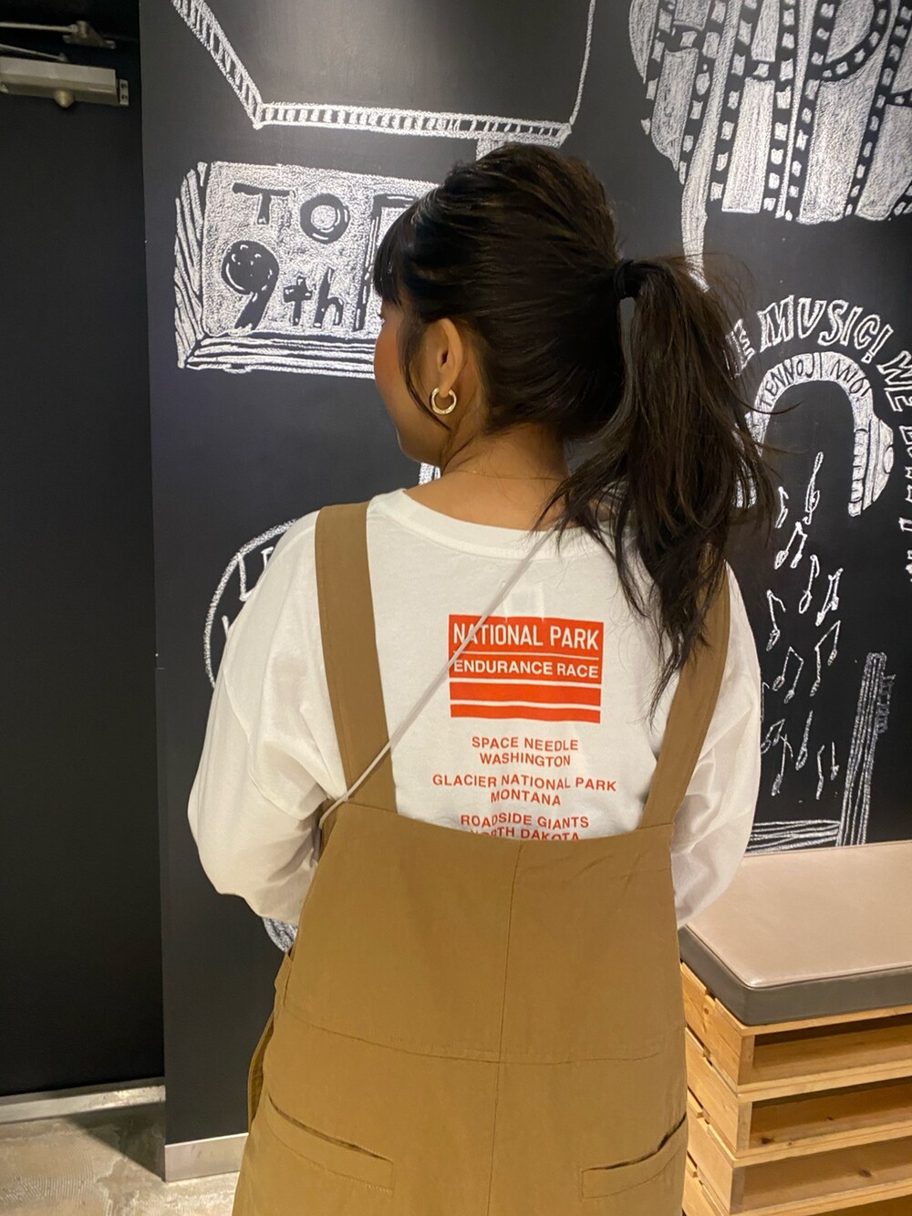 イエロー系のつなぎ/オールインワン、ホワイト系のTシャツ/カットソー、シルバー系のショルダーバッグを着用したレディースの冬コーディネートの6枚目の写真