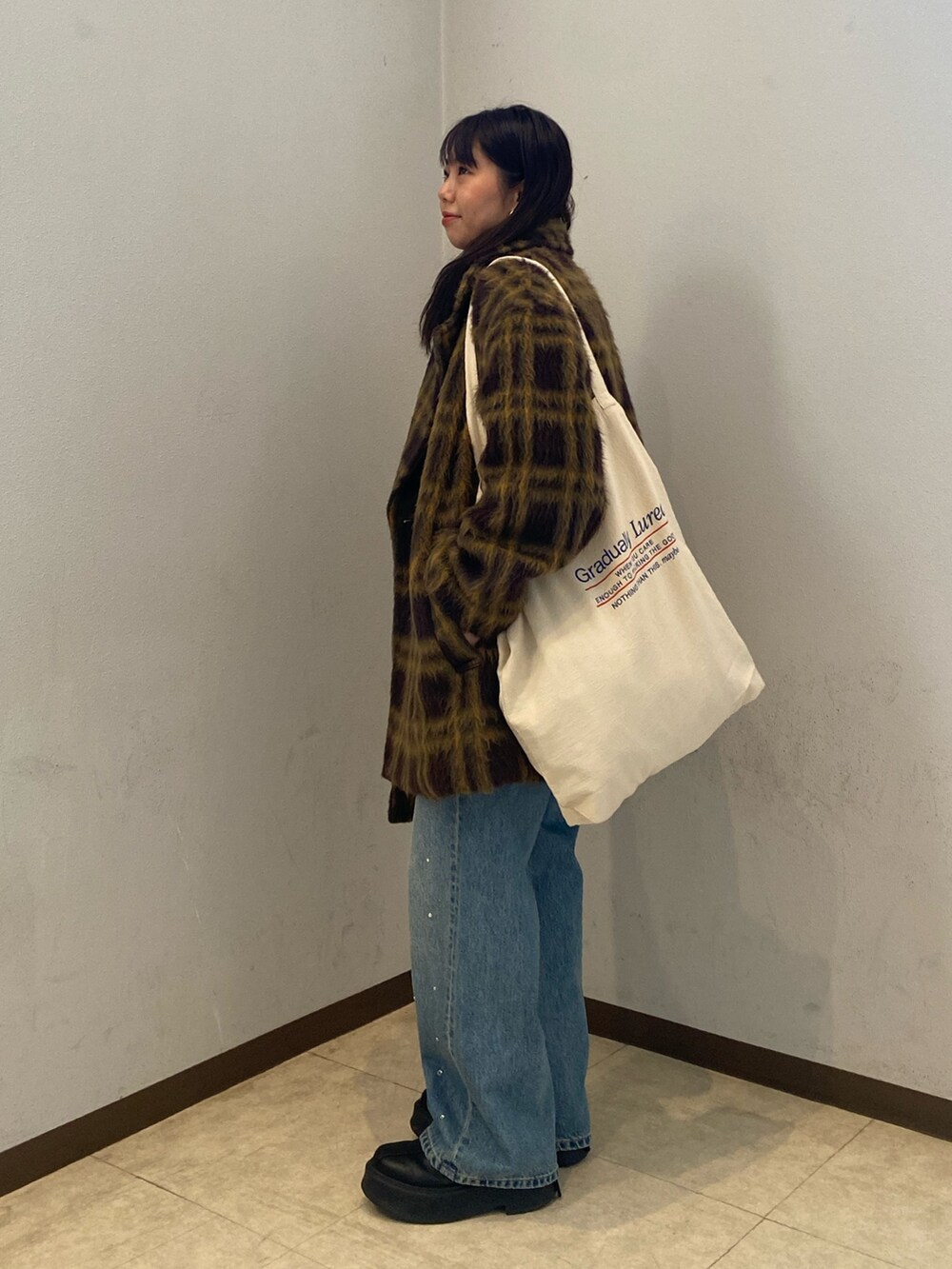 その他のピーコート、ブルー系のデニムパンツ、ブラック系のニット/セーターを着用したレディースの冬コーディネートの2枚目の写真