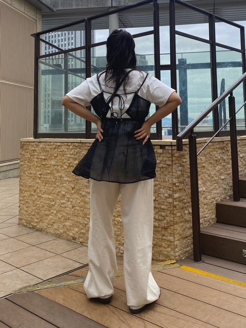 ホワイト系のTシャツ/カットソー、ブラック系のキャミソール、ホワイト系のデニムパンツを着用したレディースの春コーディネートの3枚目の写真