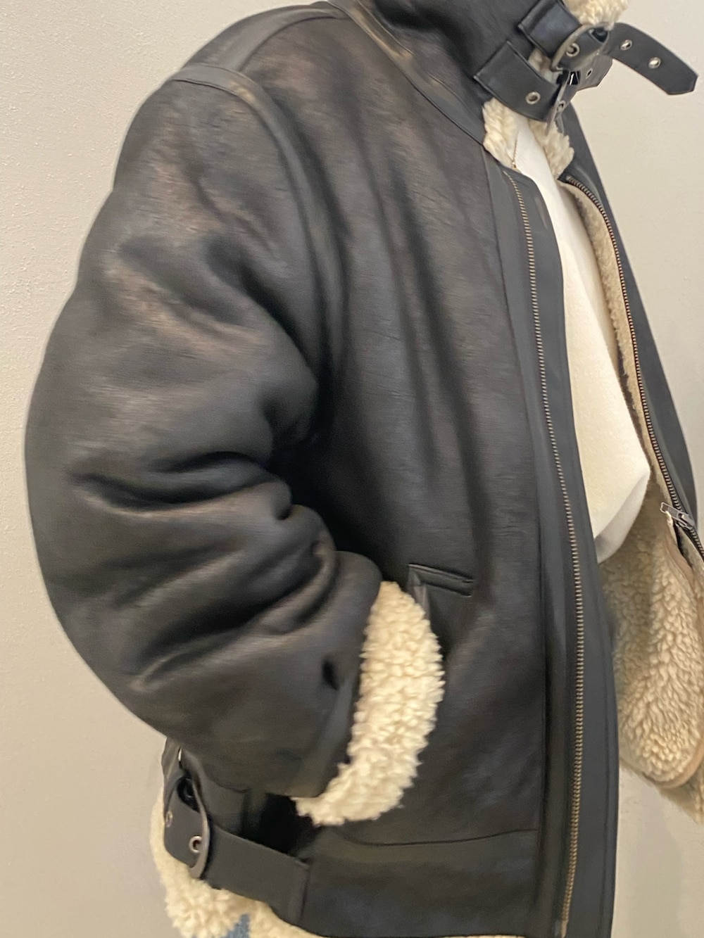 ブラック系のムートンコート、ブルー系のデニムパンツを着用したレディースの冬コーディネートの7枚目の写真