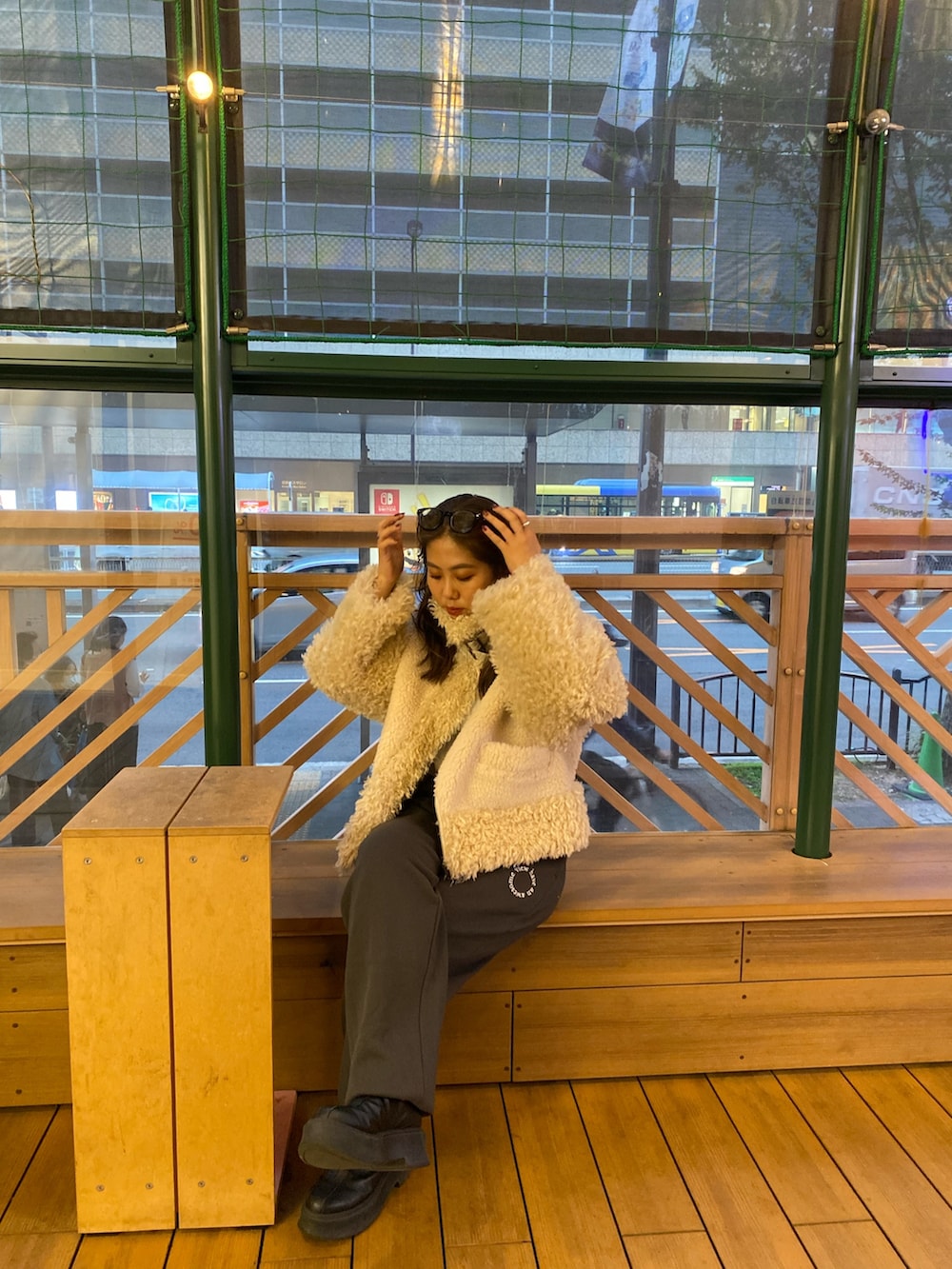 ホワイト系のムートンコート、グレー系のスウェットパンツを着用したレディースの冬コーディネートの4枚目の写真