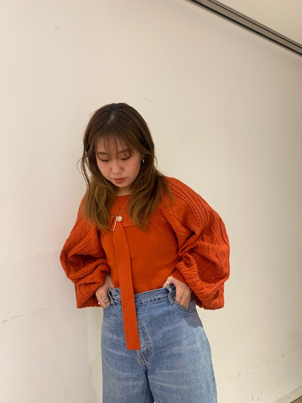 オレンジ系のカーディガン/ボレロ、ブルー系のデニムパンツ、ブラック系のブーツを着用したレディースの秋コーディネートの4枚目の写真