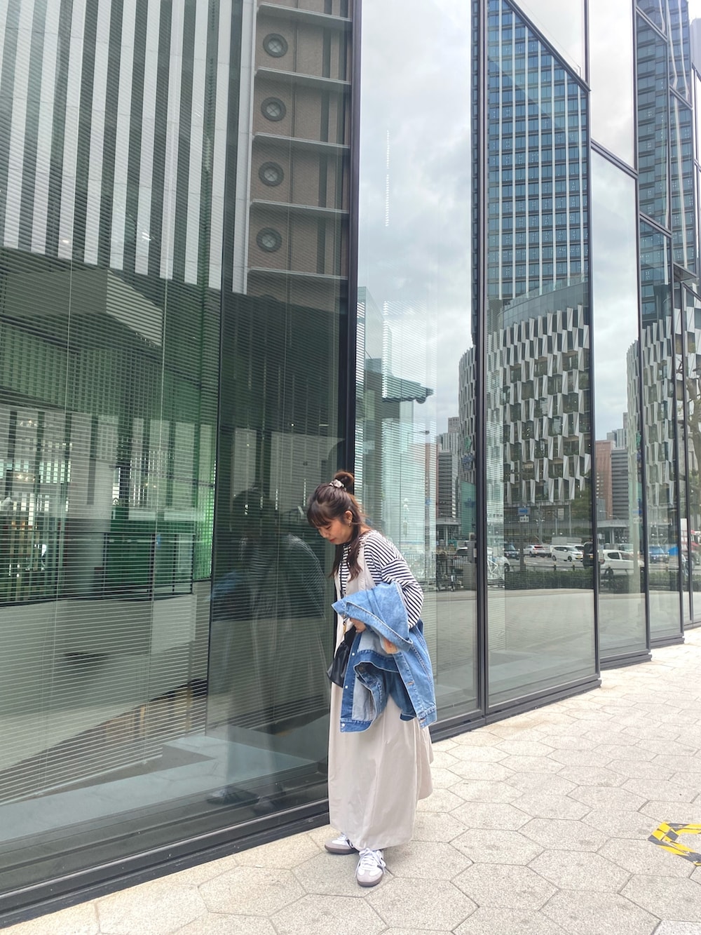 ブルー系のデニムジャケット、グレー系のワンピース、ブルー系のTシャツ/カットソーを着用したレディースの冬コーディネートの3枚目の写真