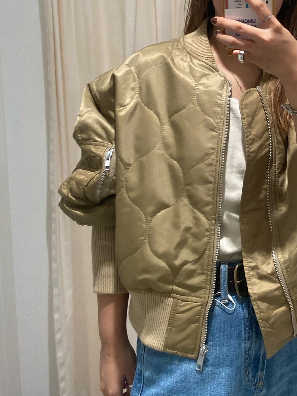 ベージュ系のブルゾン、ブルー系のデニムパンツ、ブラック系のブーツを着用したレディースの秋コーディネートの6枚目の写真