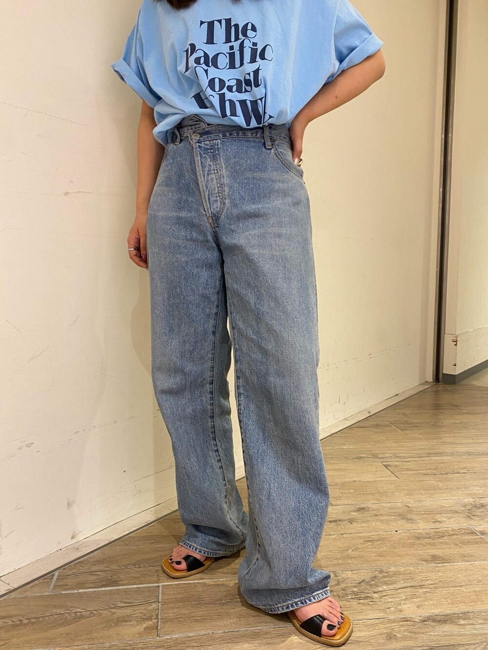 ブルー系のTシャツ/カットソー、ブルー系のデニムパンツ、ブラック系のサンダルを着用したレディースの春コーディネートの6枚目の写真