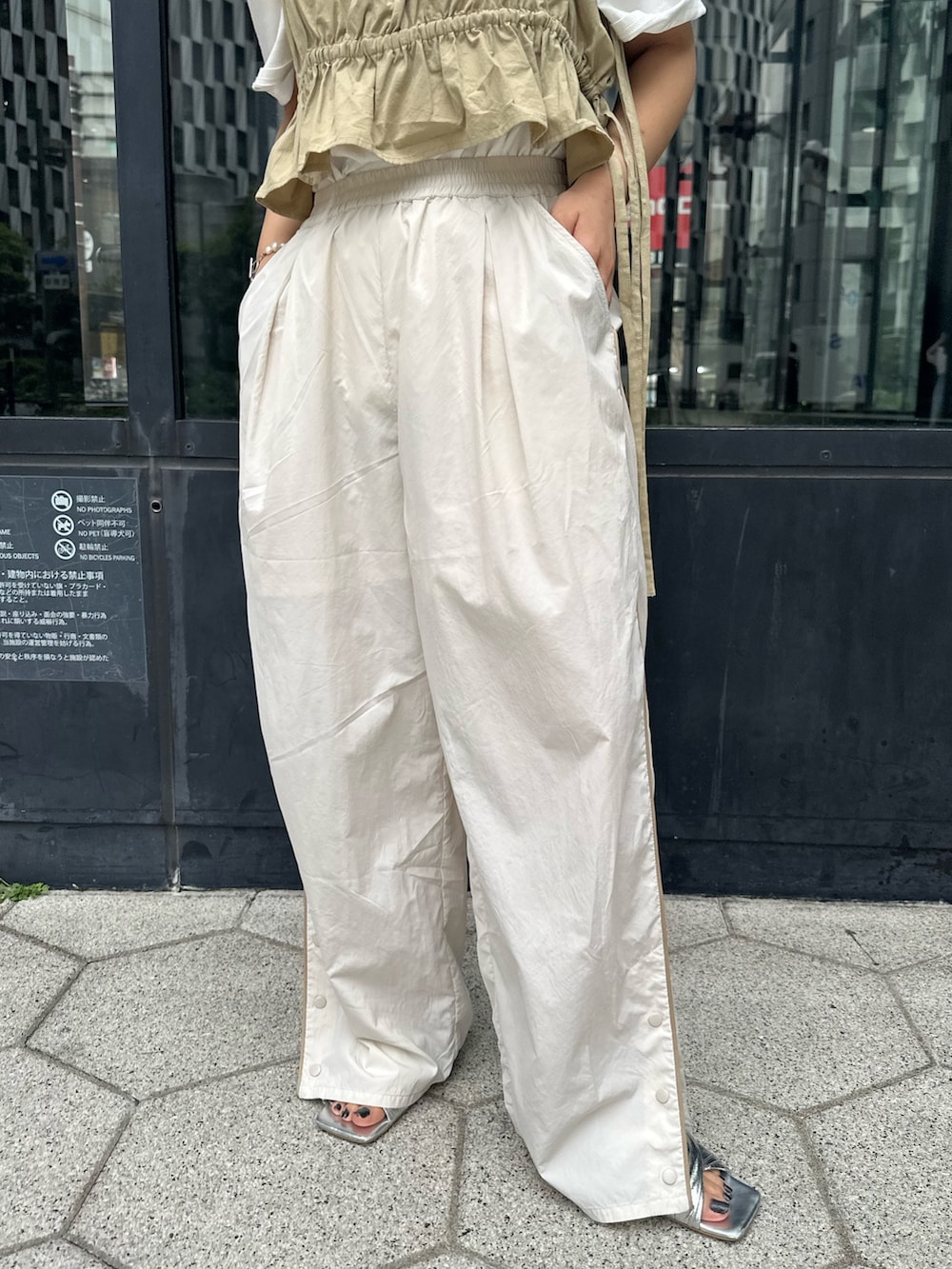 ホワイト系のTシャツ/カットソー、ホワイト系のその他パンツ、シルバー系のサンダルを着用したレディースの春コーディネートの5枚目の写真