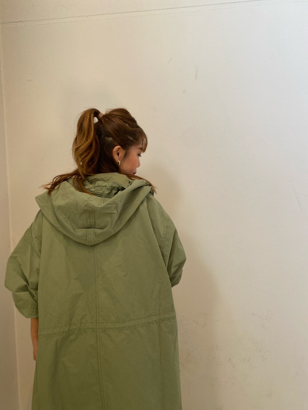 ピンク系のニット/セーター、グリーン系のブルゾン、ブルー系のデニムパンツを着用したレディースの秋コーディネートの4枚目の写真