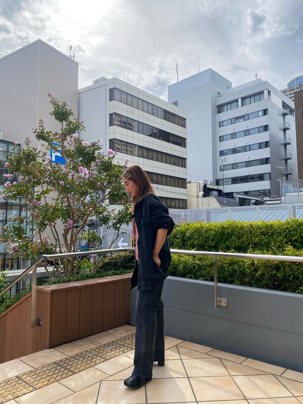 ブラック系のデニムジャケット、ブラック系のデニムパンツ、ピンク系のニット/セーターを着用したレディースの秋コーディネートの2枚目の写真