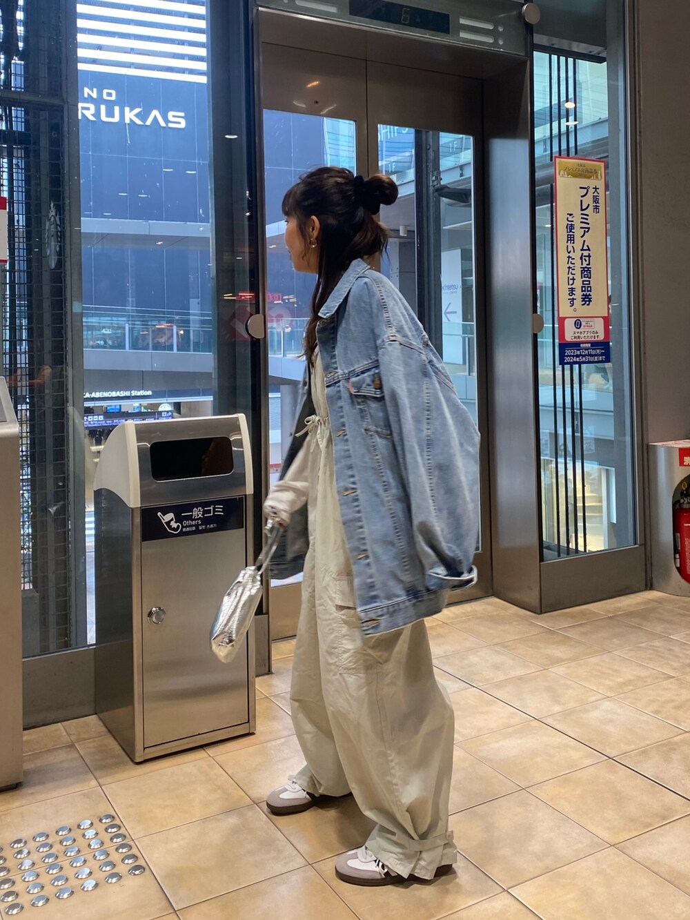 ブルー系のデニムジャケット、グレー系のサロペット/オーバーオール、ゴールド系のネックレスを着用したレディースの冬コーディネートの3枚目の写真