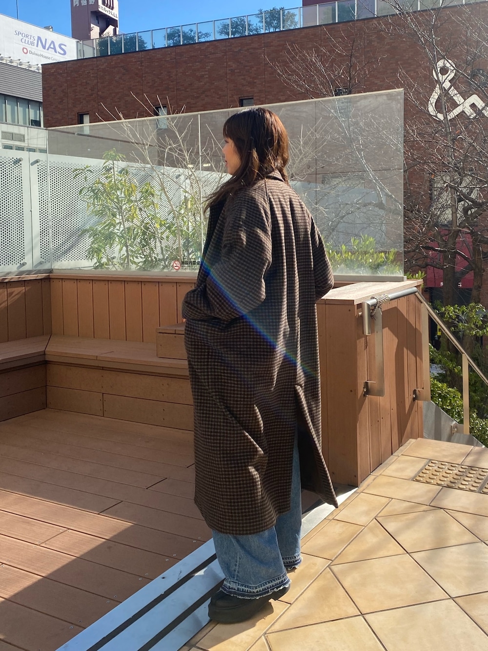 その他のチェスターコート、ブルー系のデニムパンツ、レッド系のニット/セーターを着用したレディースの冬コーディネートの2枚目の写真