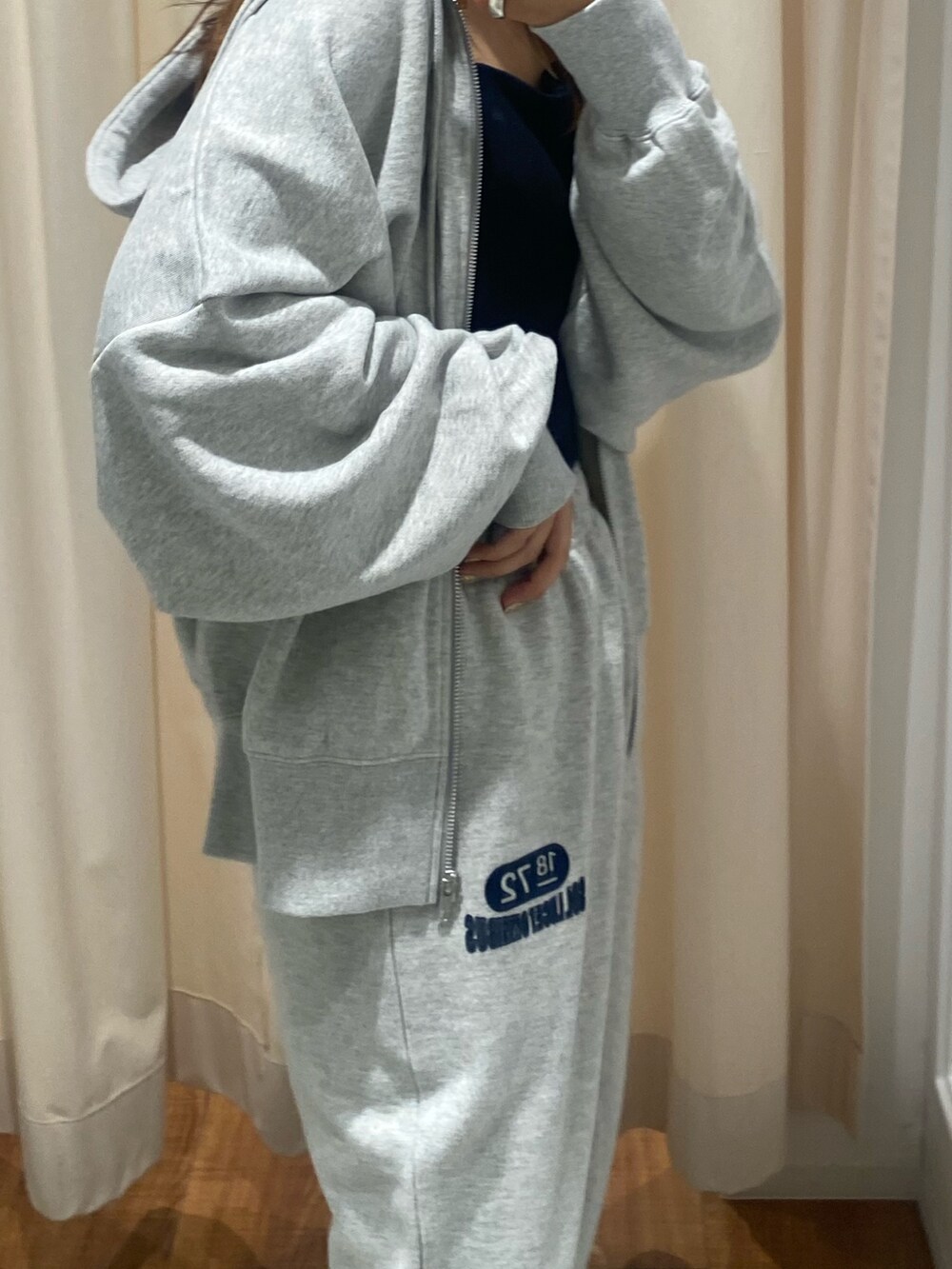 グレー系のパーカー、グレー系のスウェットパンツを着用したレディースの秋コーディネートの7枚目の写真