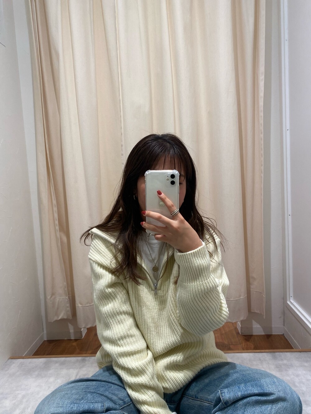 ホワイト系のニット/セーター、ブルー系のデニムパンツ、ホワイト系のTシャツ/カットソーを着用したレディースの冬コーディネートの2枚目の写真