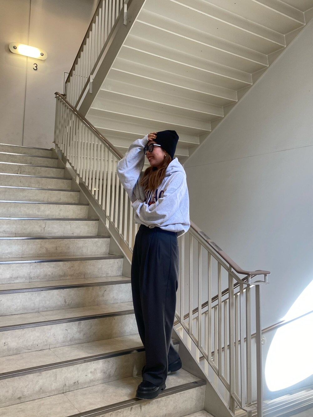 グレー系のパーカー、グレー系のその他パンツ、ブラック系のブーツを着用したレディースの秋コーディネートの3枚目の写真