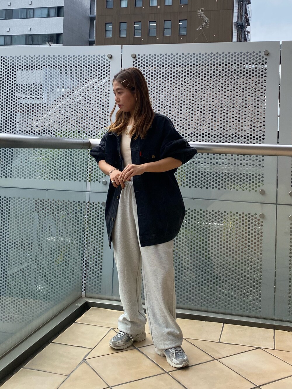ブラック系のデニムジャケット、グレー系のスウェットパンツを着用したレディースの秋コーディネートの2枚目の写真