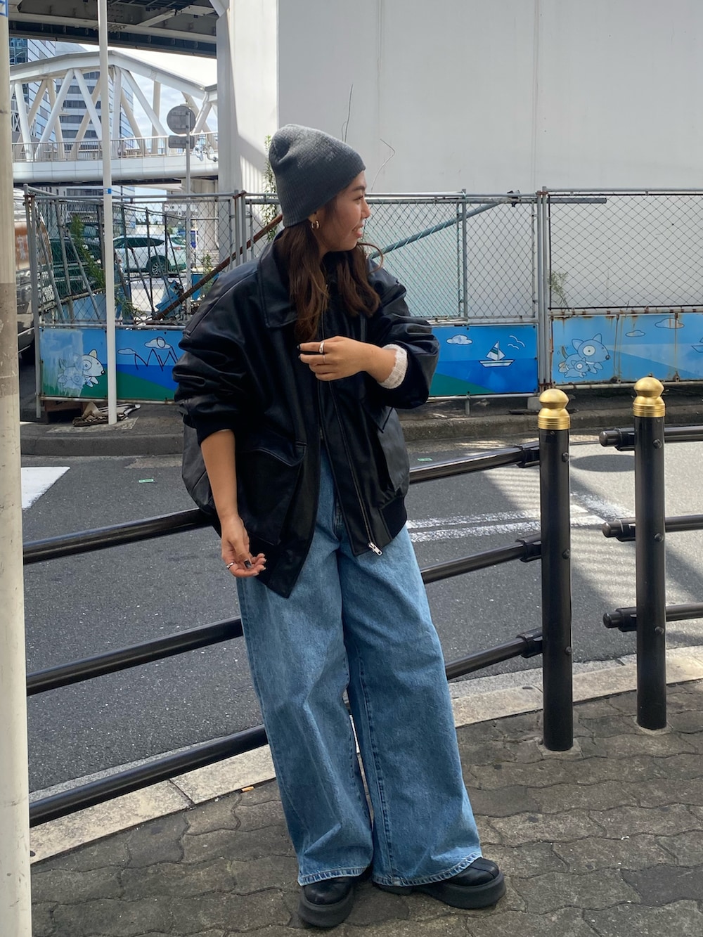 ホワイト系のニット/セーター、ブルー系のデニムパンツ、ブラック系のブルゾンを着用したレディースの秋コーディネートの4枚目の写真