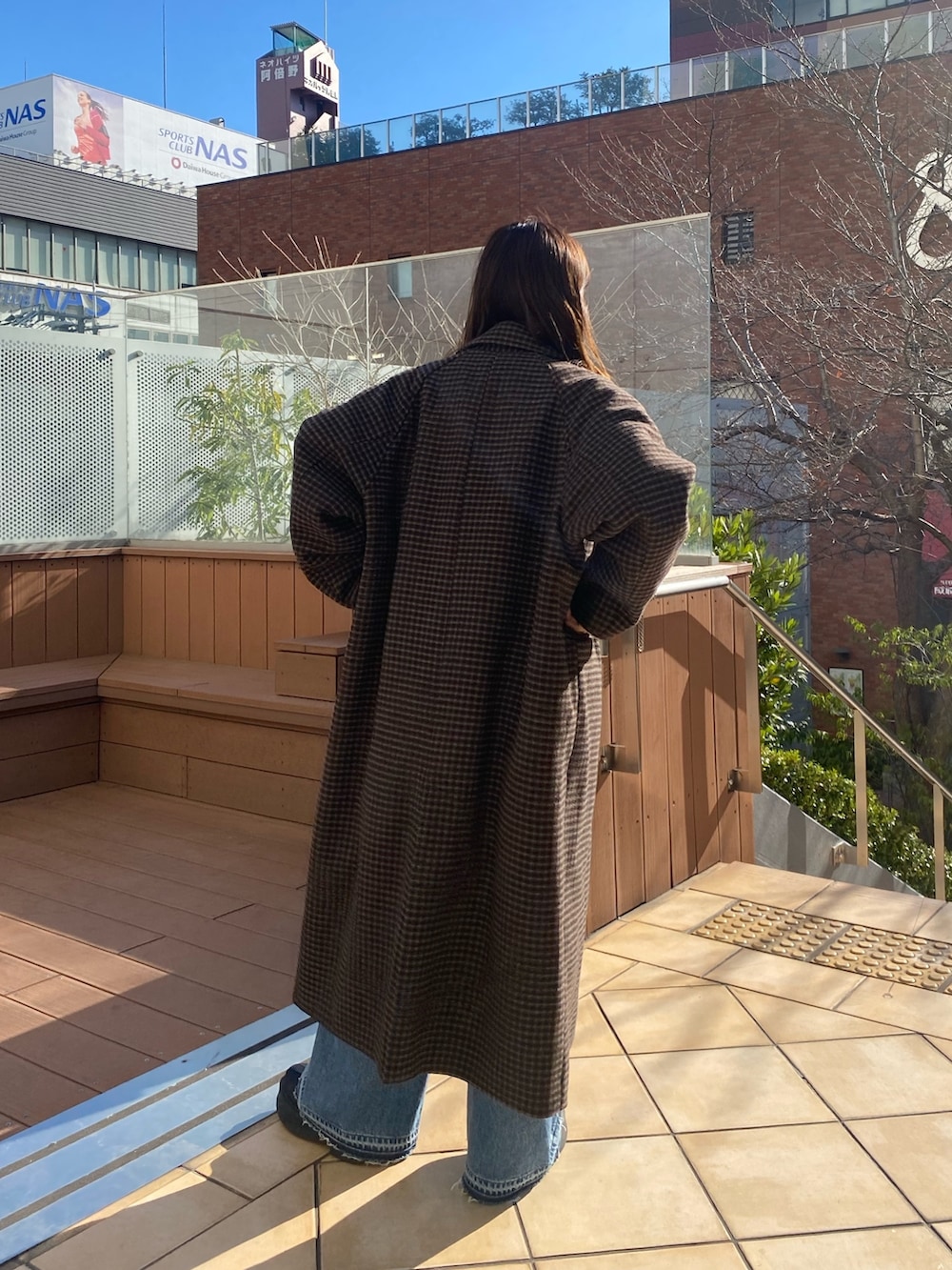 その他のチェスターコート、ブルー系のデニムパンツ、レッド系のニット/セーターを着用したレディースの冬コーディネートの3枚目の写真