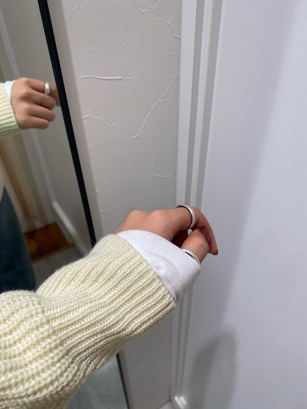 ホワイト系のニット/セーター、ブルー系のデニムパンツ、ホワイト系のTシャツ/カットソーを着用したレディースの冬コーディネートの7枚目の写真