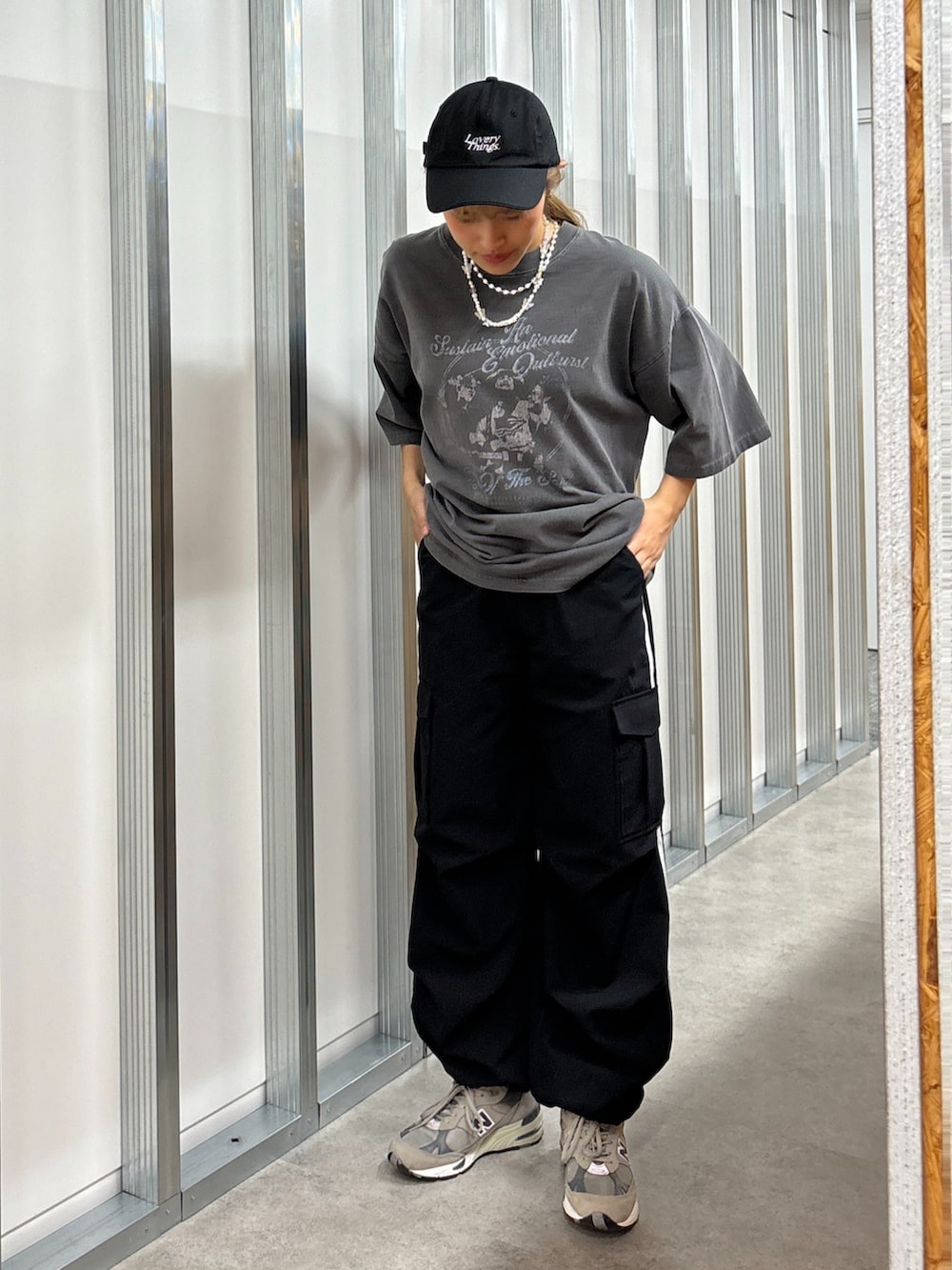 その他のTシャツ/カットソー、ブラック系のカーゴパンツ、ブラック系のキャップを着用したレディースの春コーディネートの2枚目の写真