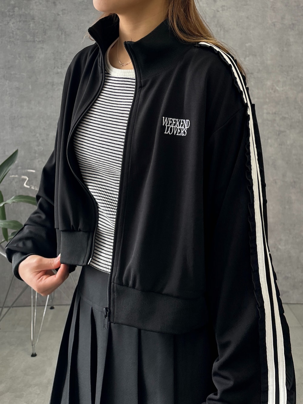 ブラック系のジャージ、ホワイト系のTシャツ/カットソー、ブラック系のスカートを着用したレディースの春コーディネートの2枚目の写真