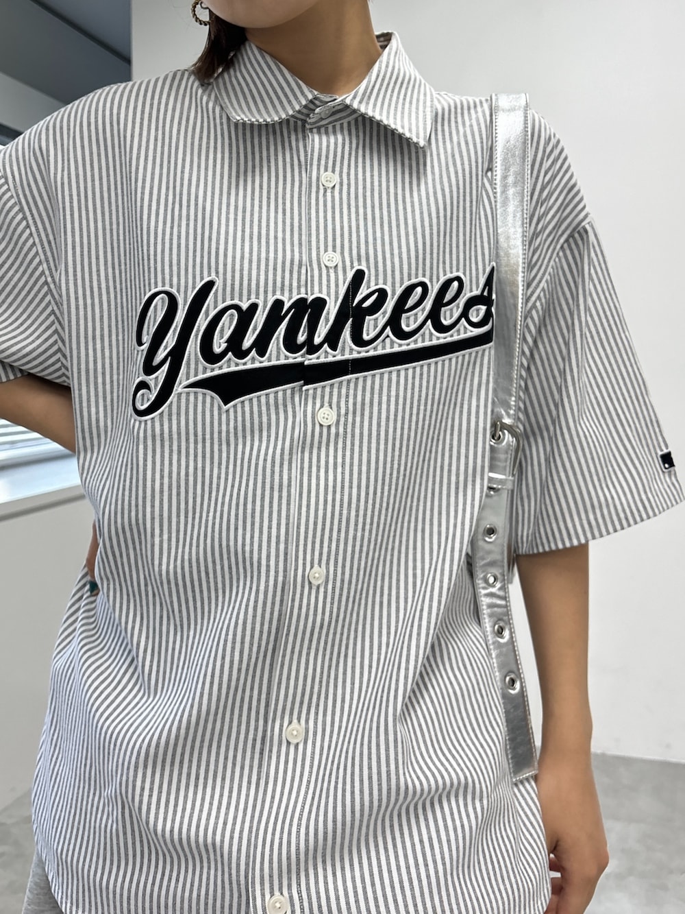 ホワイト系のシャツ/ブラウス、シルバー系のハンドバッグ、グレー系のスカートを着用したレディースの夏コーディネートの2枚目の写真