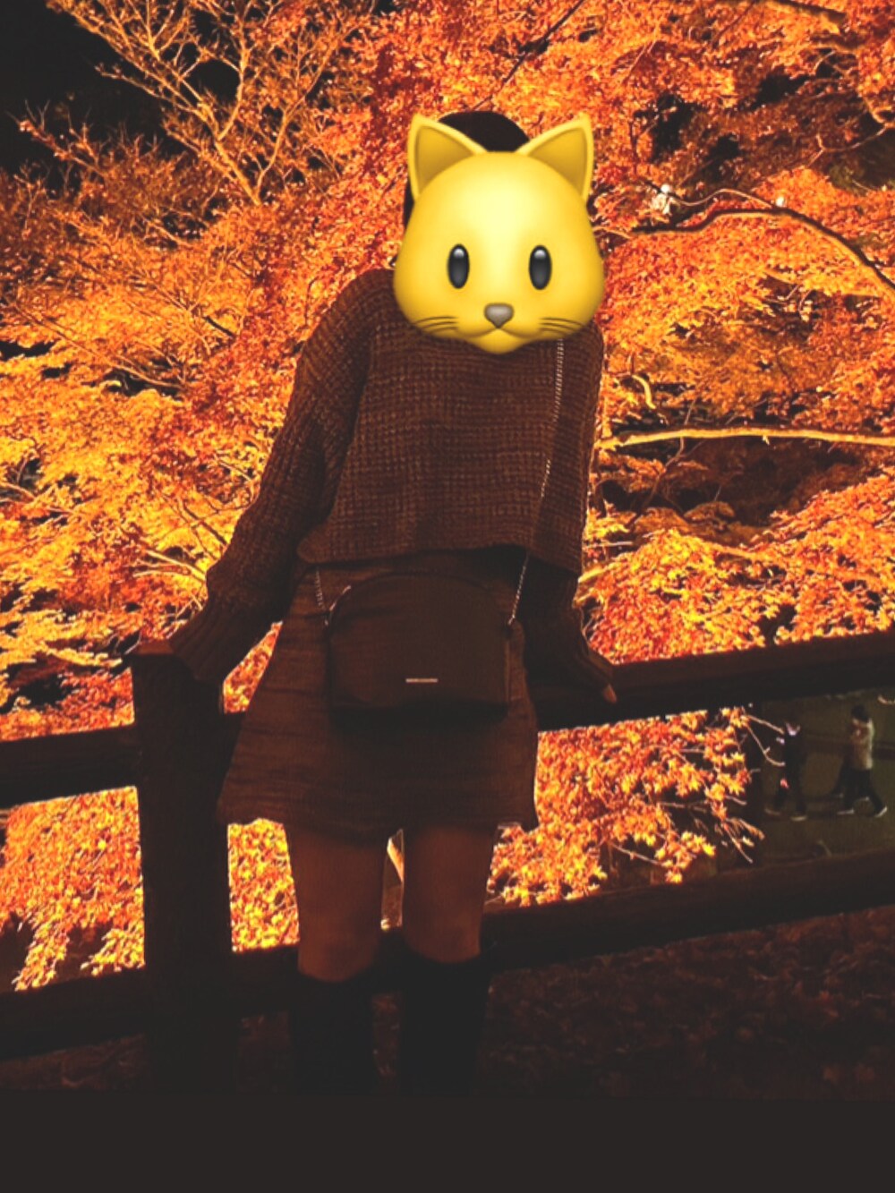 オレンジ系のトップスを着用したレディースの秋コーディネートの2枚目の写真