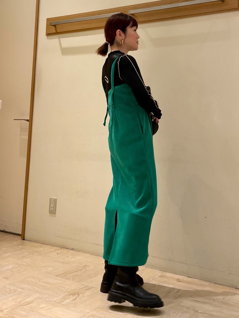 グリーン系のワンピース、ブラック系のブーツ、ブルー系のTシャツ/カットソーを着用したレディースの冬コーディネートの3枚目の写真