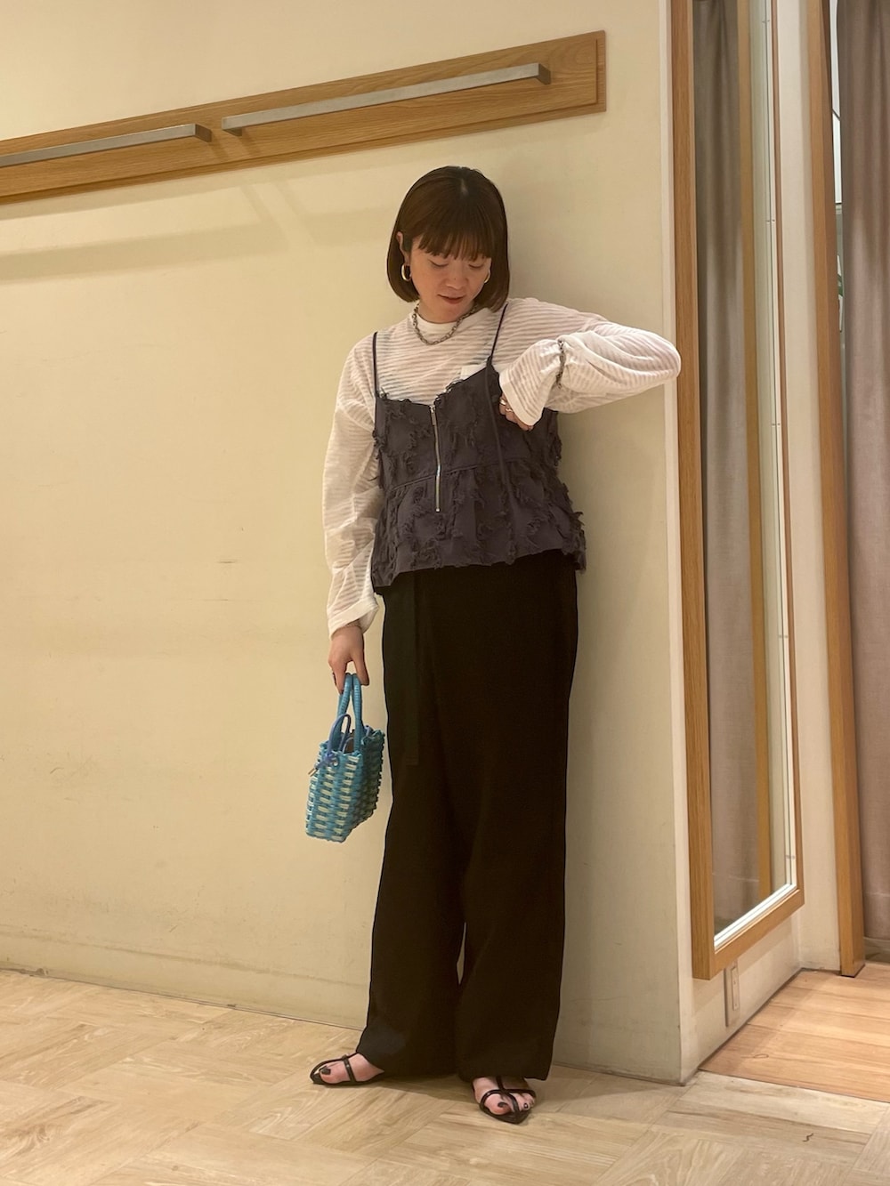 ブラック系のサンダル、ブルー系のショルダーバッグ、ホワイト系のTシャツ/カットソーを着用したレディースの春コーディネートの2枚目の写真