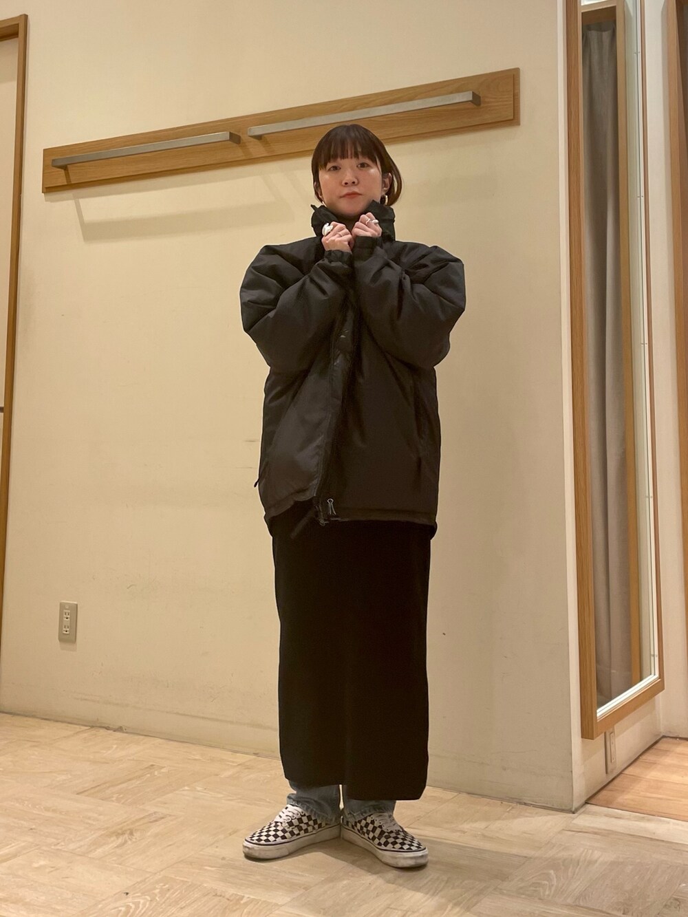 ブラック系のダウンジャケット/コート、ブラック系のワンピース、ブルー系のTシャツ/カットソーを着用したレディースの冬コーディネートの3枚目の写真