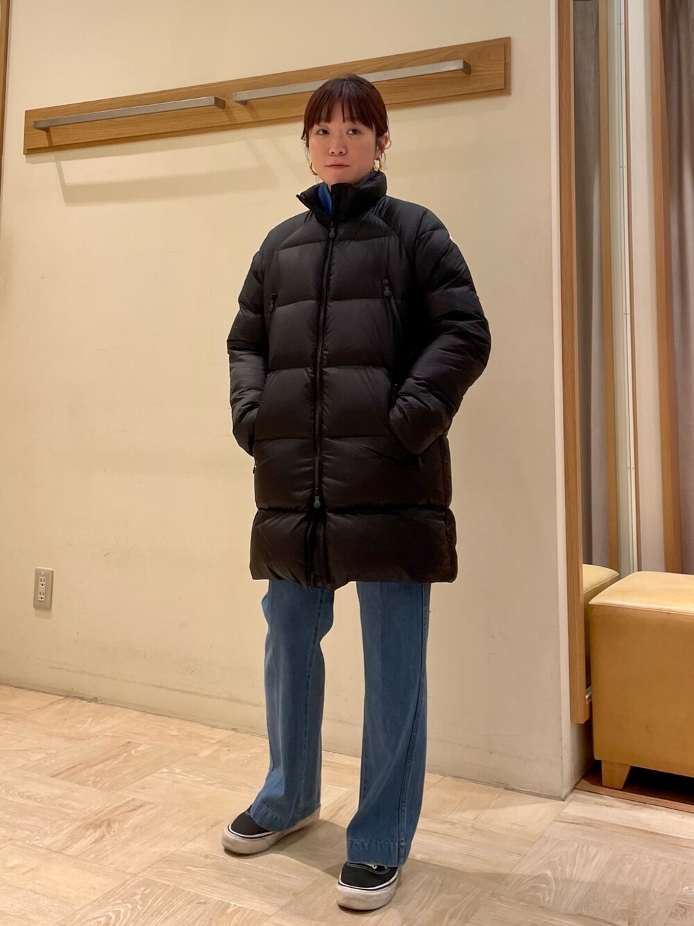 ブルー系のデニムパンツ、ブラック系のダウンジャケット/コート、ゴールド系のピアス（両耳用）を着用したレディースの冬コーディネートの3枚目の写真