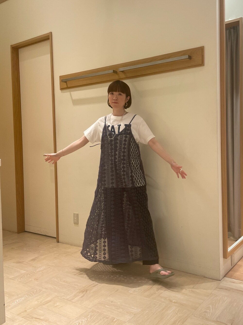 ホワイト系のTシャツ/カットソー、ブラック系のスラックス、グリーン系のサンダルを着用したレディースの春コーディネートの3枚目の写真