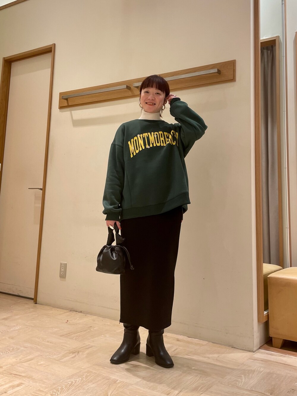 ブラック系のブーツ、ブラック系のスカート、グリーン系のスウェットを着用したレディースの冬コーディネートの3枚目の写真