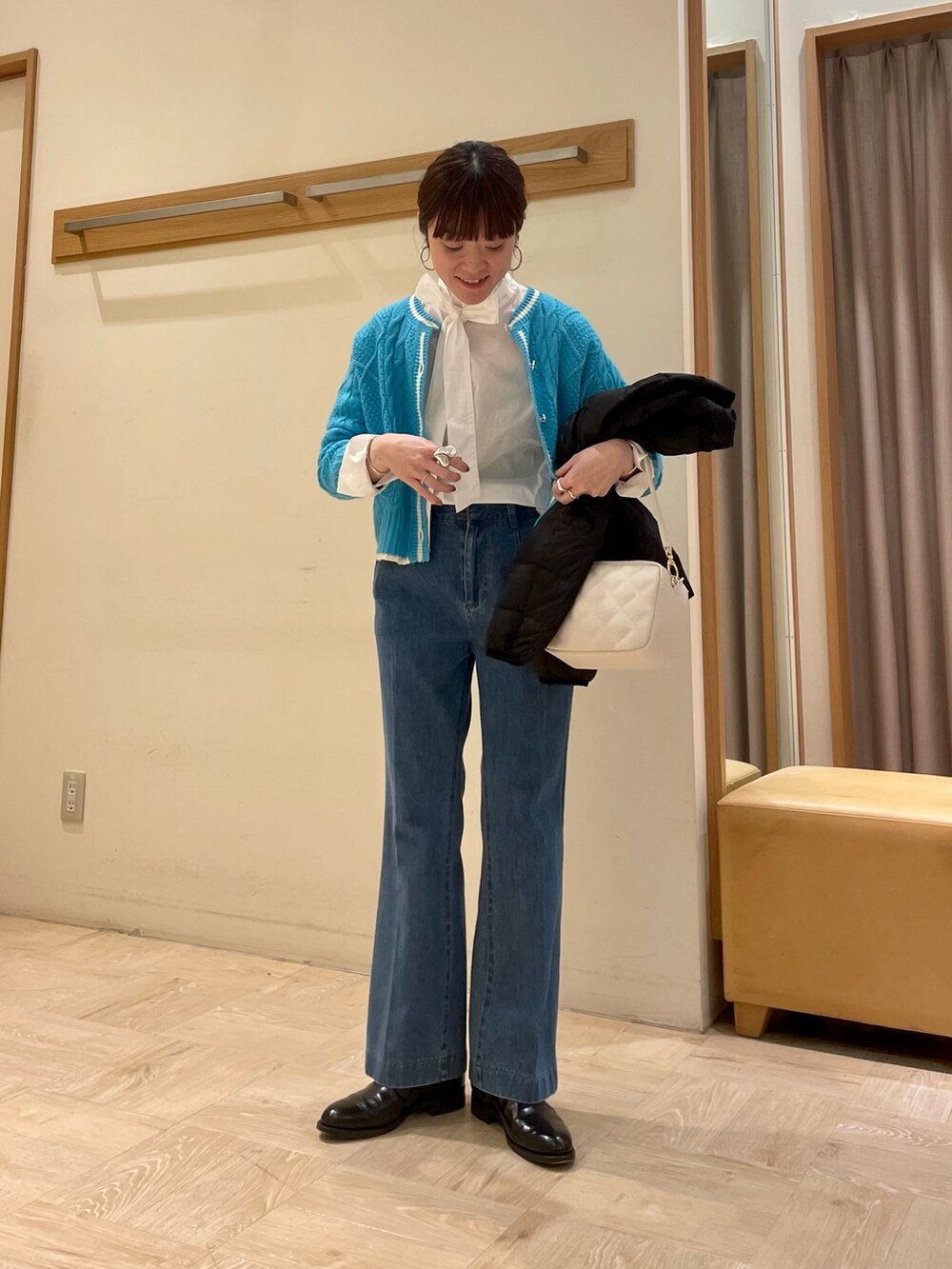 ブラック系のブーツ、ブラック系のダウンジャケット/コート、ブルー系のカーディガン/ボレロを着用したレディースの冬コーディネートの2枚目の写真