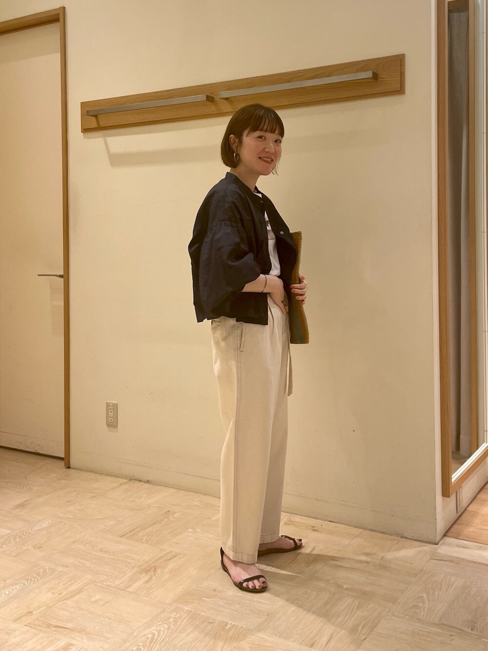 ブラック系のサンダル、ブルー系のシャツ/ブラウス、ホワイト系のデニムパンツを着用したレディースの春コーディネートの2枚目の写真