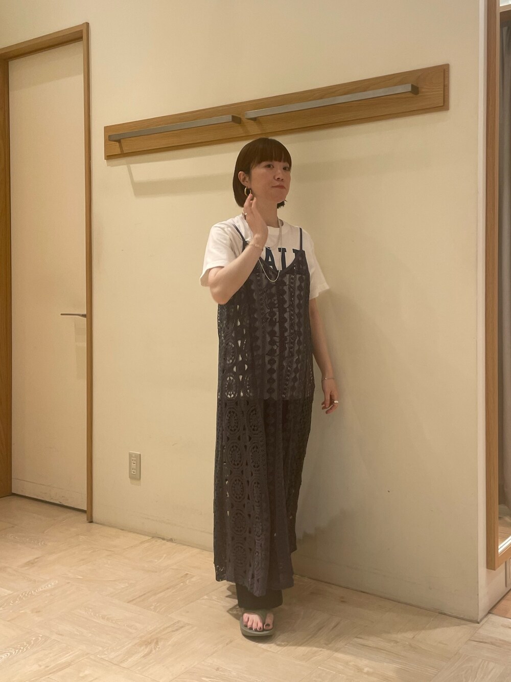 ホワイト系のTシャツ/カットソー、ブラック系のスラックス、グリーン系のサンダルを着用したレディースの春コーディネートの2枚目の写真