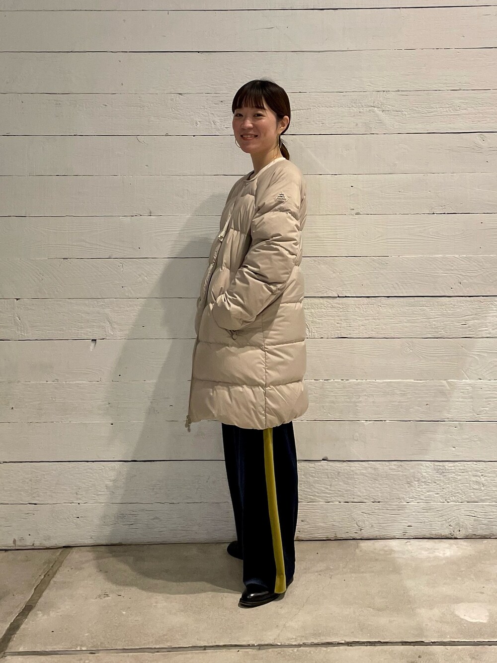 ベージュ系のダウンジャケット/コートを着用したレディースの冬コーディネートの2枚目の写真