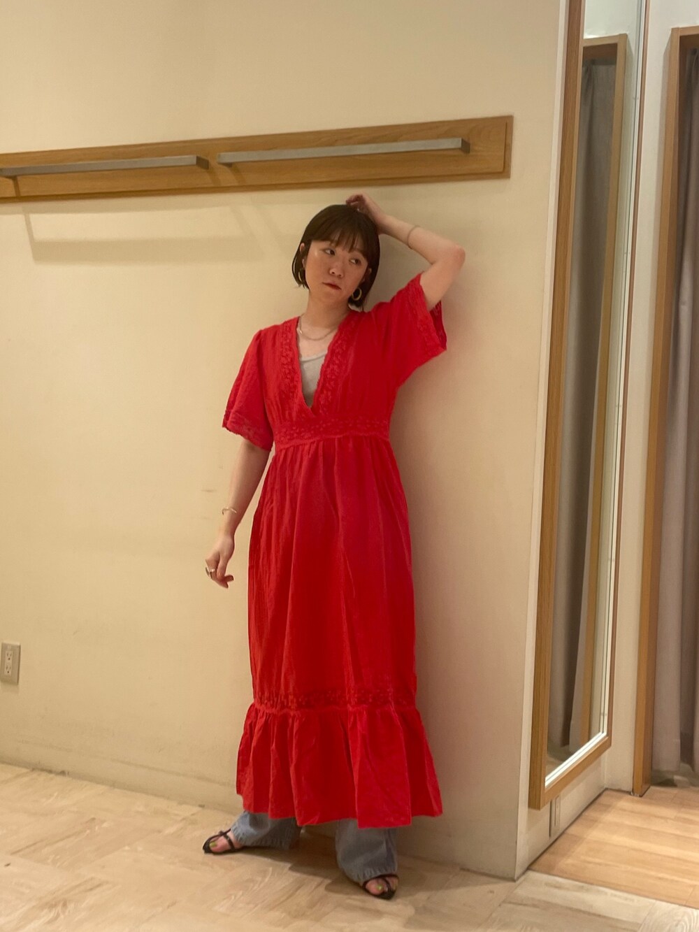 レッド系のワンピース、シルバー系のTシャツ/カットソー、ブルー系のデニムパンツを着用したレディースの夏コーディネートの2枚目の写真