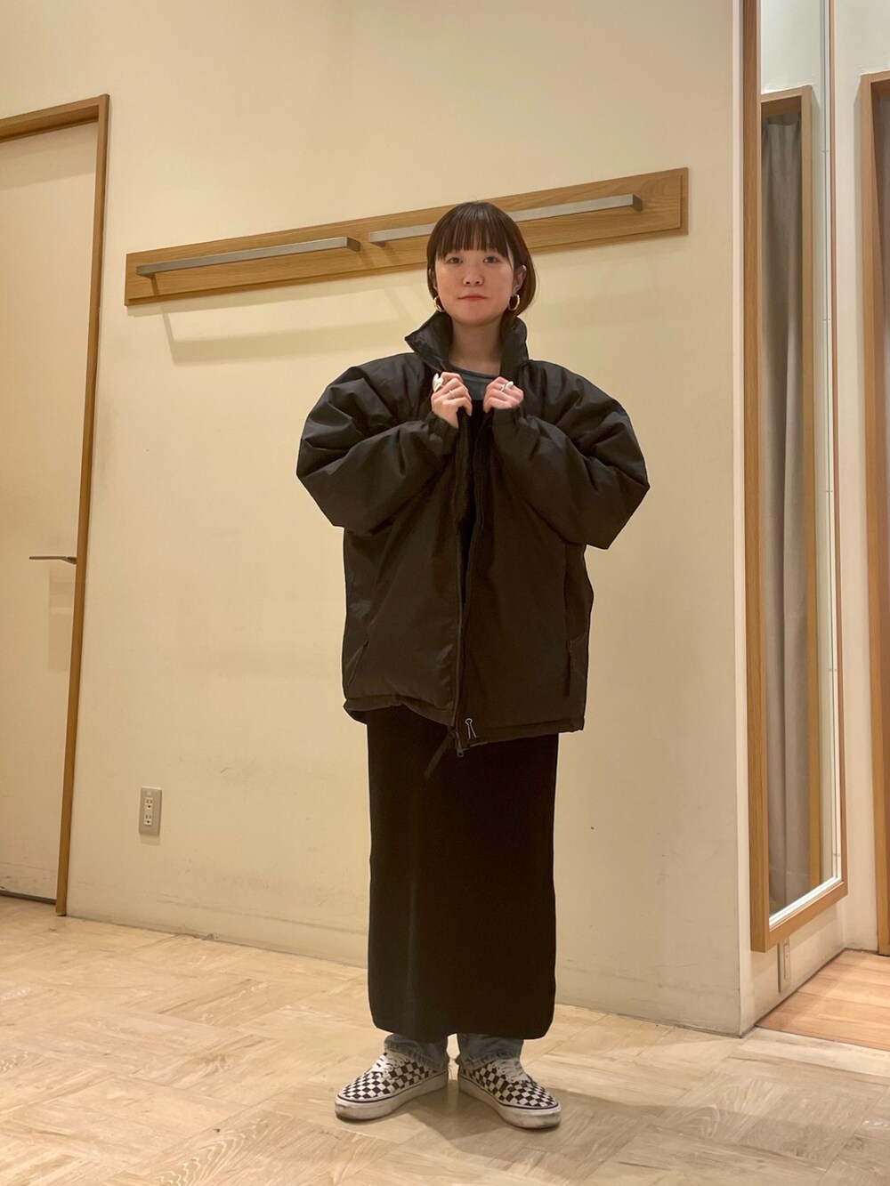 ブラック系のダウンジャケット/コート、ブラック系のワンピース、ブルー系のTシャツ/カットソーを着用したレディースの冬コーディネートの4枚目の写真