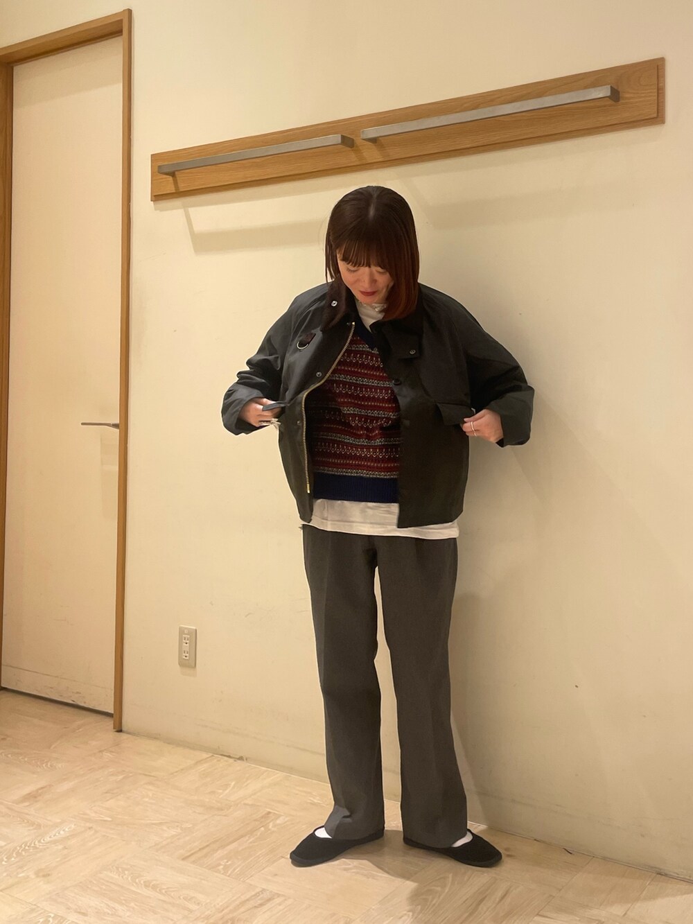 グリーン系のブルゾン、ブルー系のベスト、ホワイト系のTシャツ/カットソーを着用したレディースの秋コーディネートの2枚目の写真