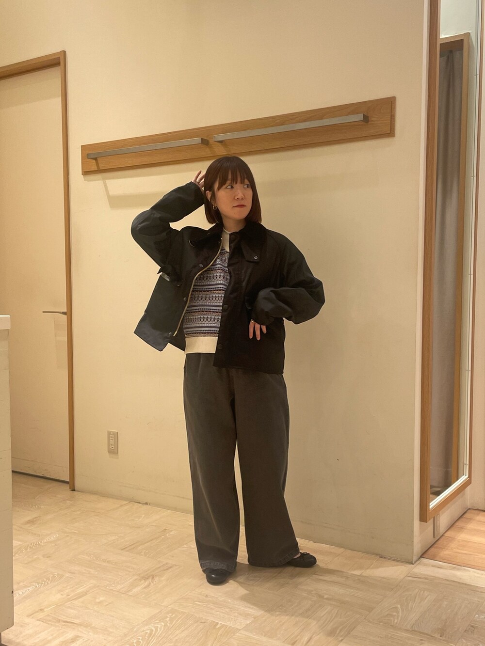 グレー系のデニムパンツ、ホワイト系のベスト、グリーン系のブルゾンを着用したレディースの秋コーディネートの2枚目の写真