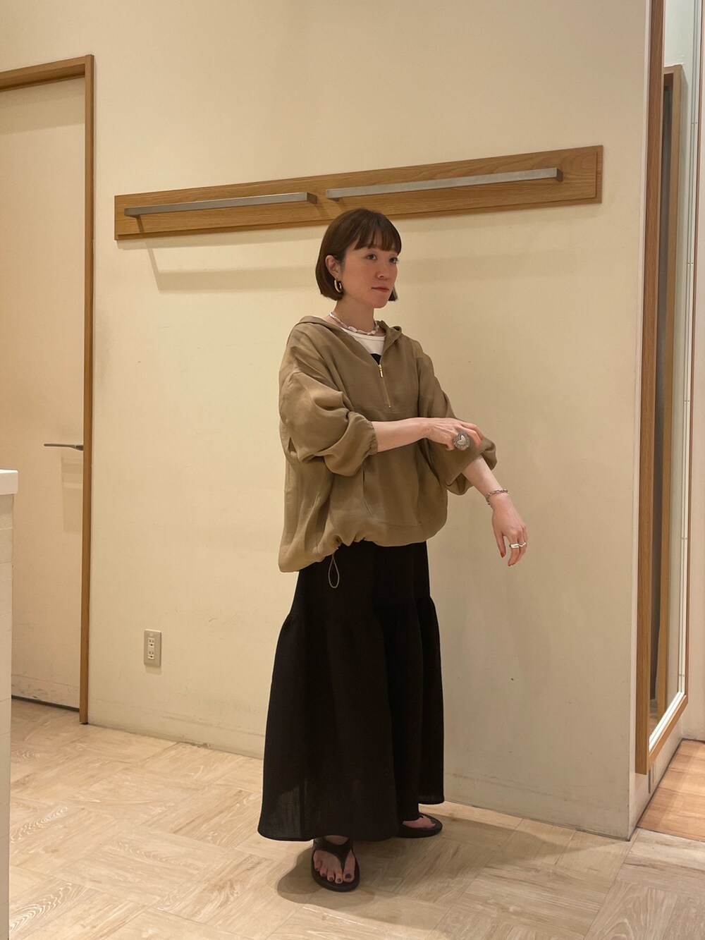 ブラック系のサンダル、ブラック系のワンピース、ベージュ系のブルゾンを着用したレディースの春コーディネートの3枚目の写真