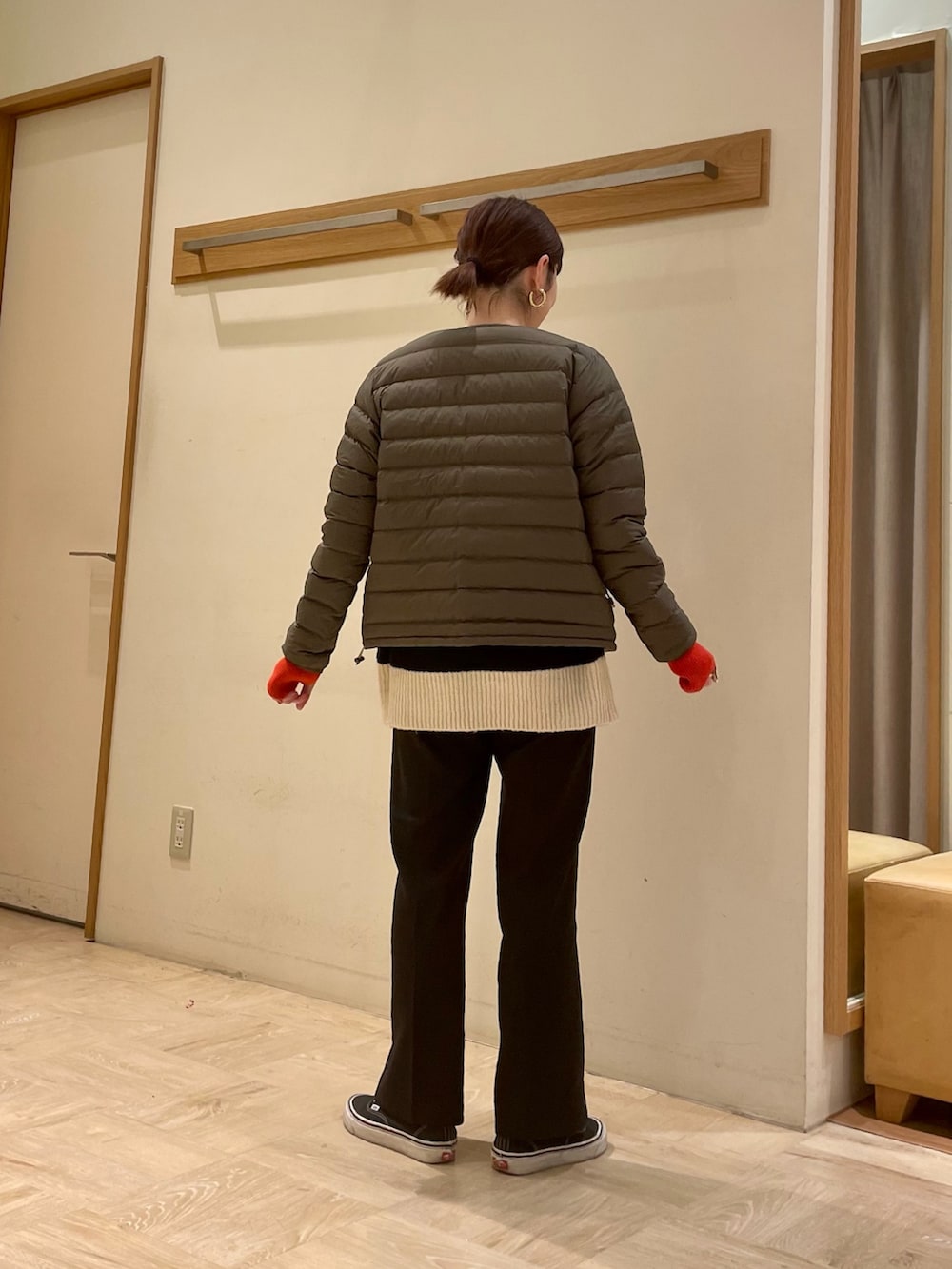 ホワイト系のニット/セーター、グリーン系のダウンジャケット/コート、オレンジ系の手袋を着用したレディースの冬コーディネートの3枚目の写真