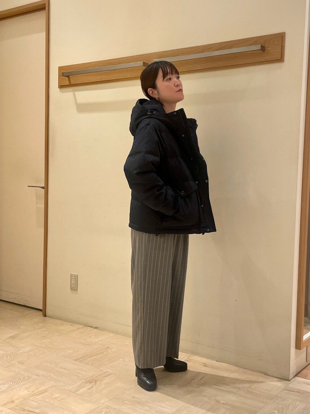 ブラック系のその他パンツ、グリーン系のニット/セーター、ブラック系のダウンジャケット/コートを着用したレディースの冬コーディネートの2枚目の写真