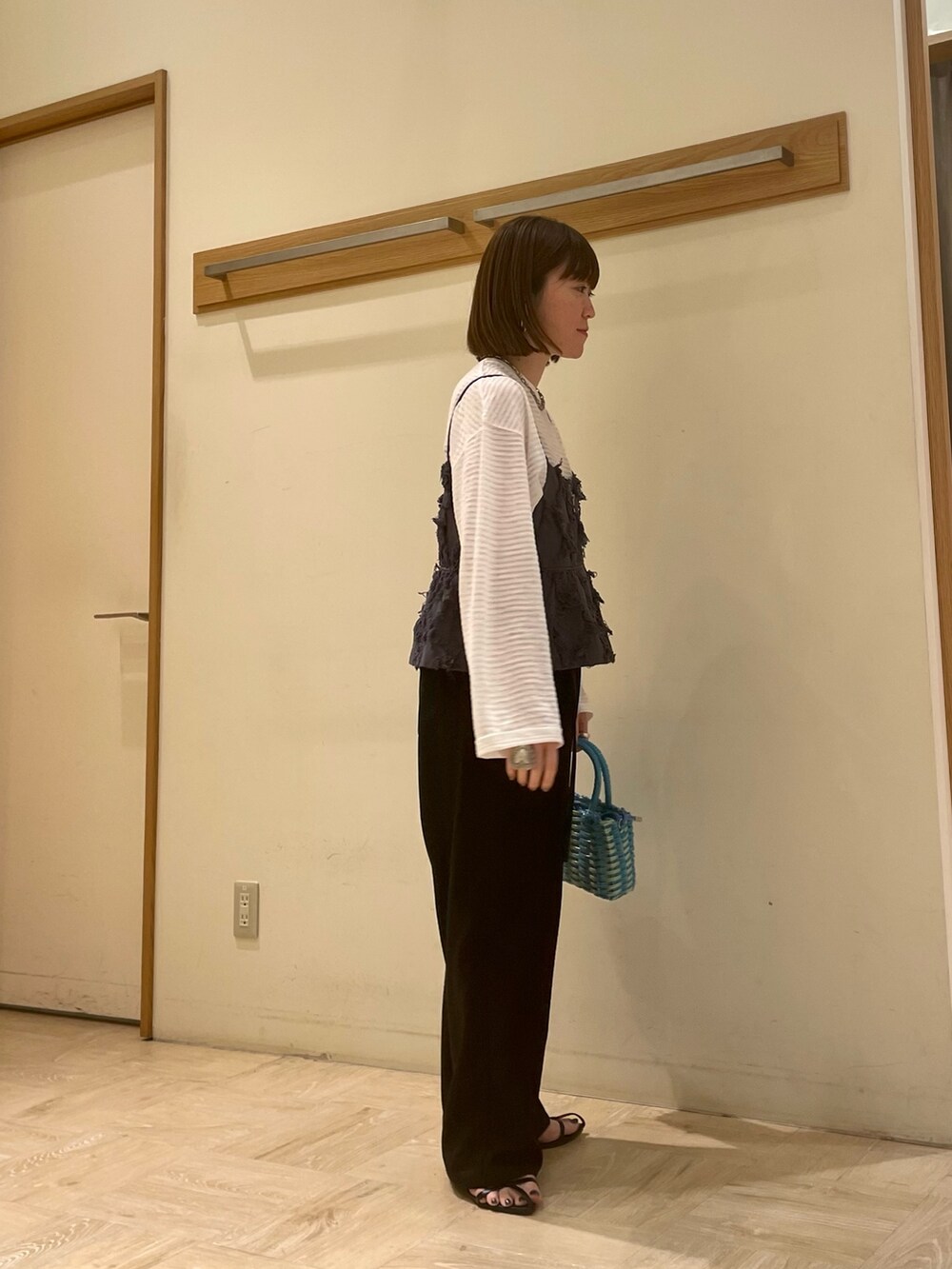 ブラック系のサンダル、ブルー系のショルダーバッグ、ホワイト系のTシャツ/カットソーを着用したレディースの春コーディネートの3枚目の写真